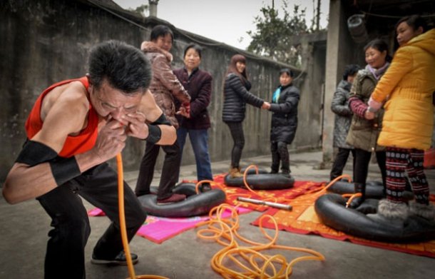 بالصور رجل صيني ينفخ 4 إطارات باستخدام أنفه