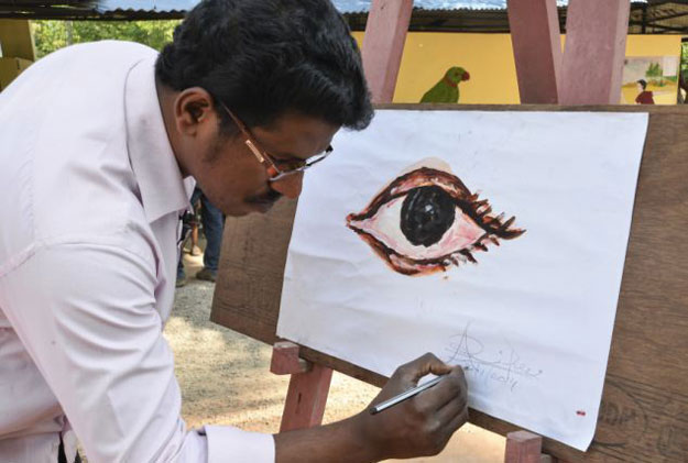 رسام هندي يبدع برسم الف لوحة باستخدام لسانه - صور وفيديو