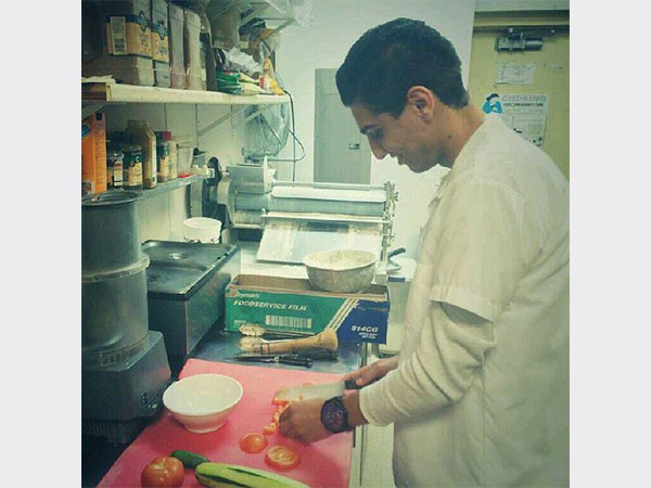 صورة محمد عساف وهو يجهز طعامه في المطبخ