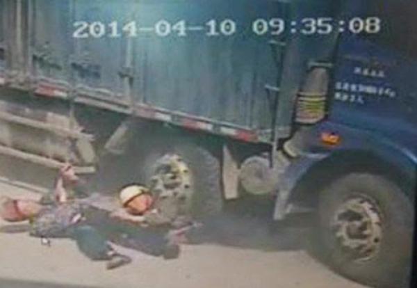بالصور اب صيني يضحي بحياته لينقذ ابنه من تحت عجلات الشاحنة