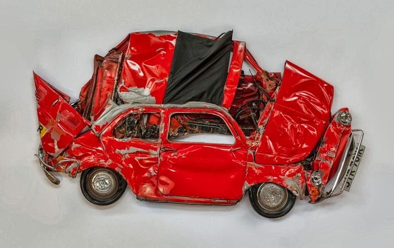 بالصور فنان يضغط هياكل السيارات ويحولها لتحف فنية